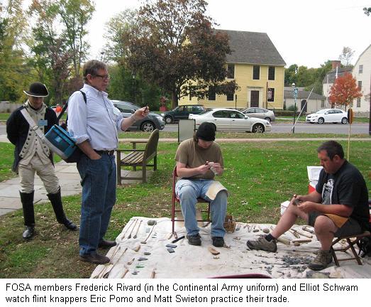 FOSA members Frederick Rivard (in the Continental Army uniform), 
                                           Elliot Schwam watch flint knappers Eric Pomo and Matt Swieton 
                                           practice their trade.